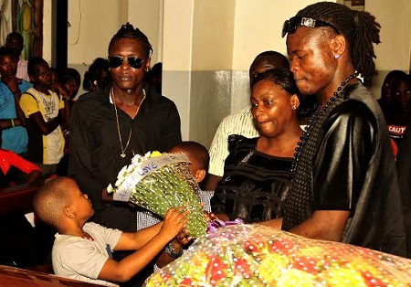 Chameleone's son's laying a wreath on the casket
