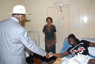 The President shaking Bebe Cool's hands as Zuena looks on